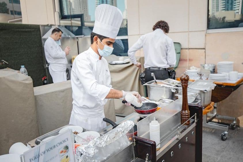 Chef friendo un huevo en una cocina.
