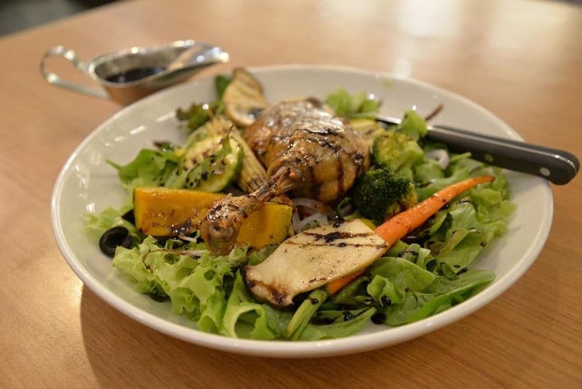 Pato tierno en un plato de ensalada.