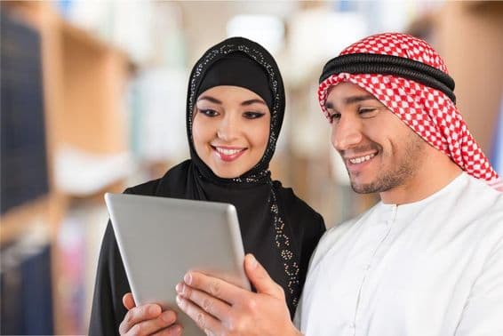 Estudiantes de árabe mirando material de estudio en una tableta.