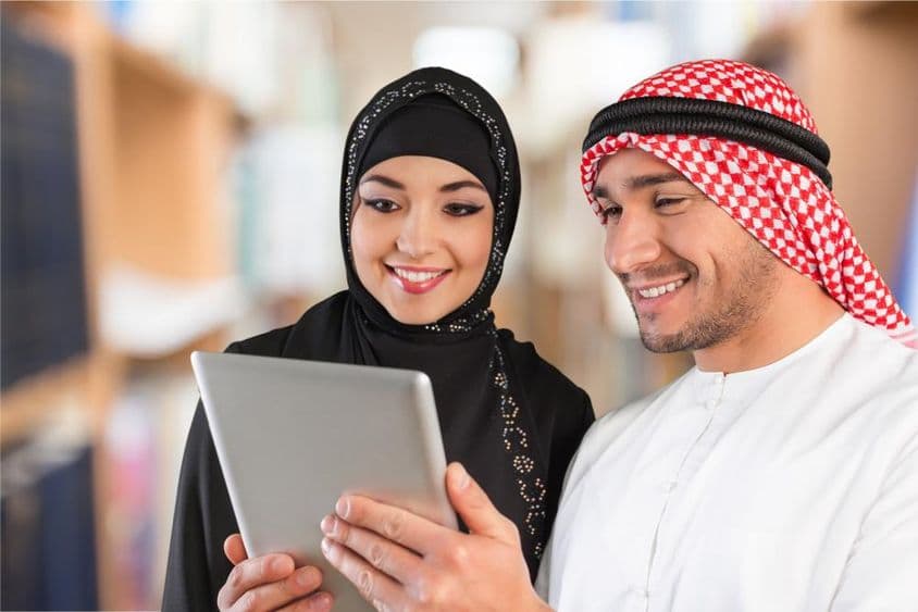 Estudiantes de árabe mirando material de estudio en una tableta.
