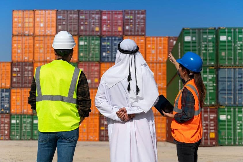 Empresario y ingenieros del Medio Oriente trabajando en un gran muelle comercial.