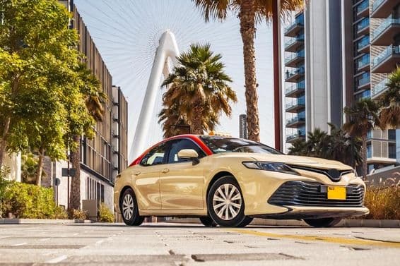 Taxi de Dubái, con palmeras al fondo.