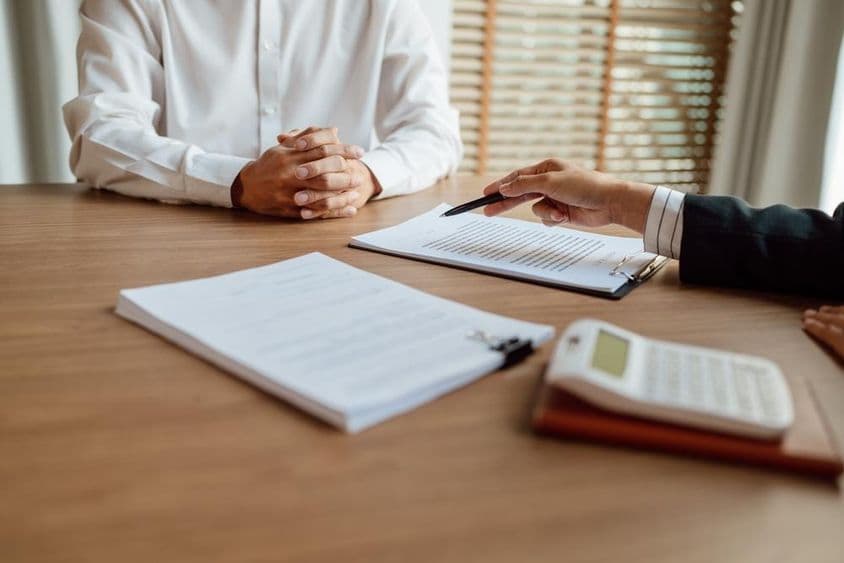 Agente de seguros firmando un contrato.