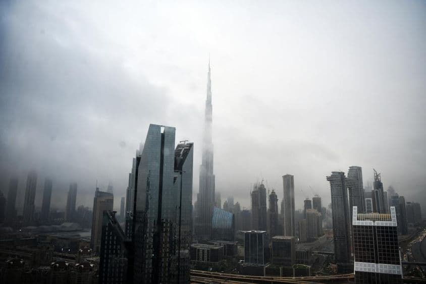 Horizonte de Dubái con edificios envueltos en nubes.
