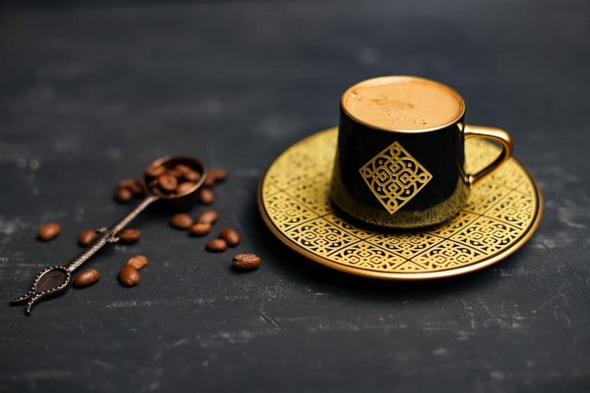 Taza y platillo de café recubiertos de oro.