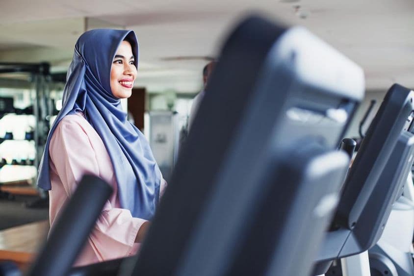 Mujer musulmana hace ejercicio en un gimnasio, lleva un hiyab.