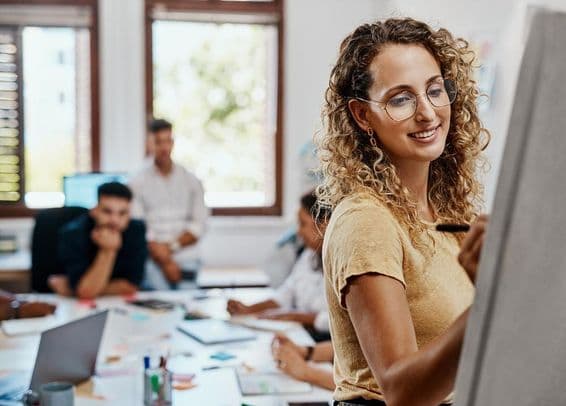 Reunión de coaching y presentación con una diseñadora en un lugar de trabajo creativo para el desarrollo de habilidades.