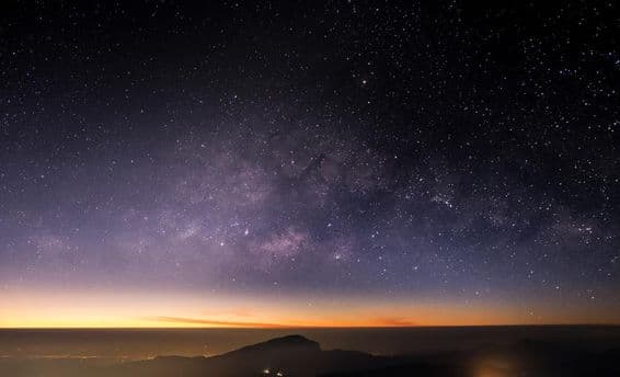 Altas montañas, noche, Vía Láctea y estrellas en el cielo nocturno son hermosas.
