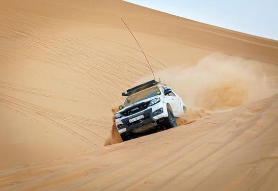 Vehículo 4x4 compitiendo en una duna.