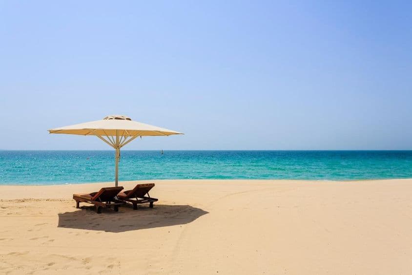 Tumbonas al sol en la playa de arena Jumeirah, Dubái.