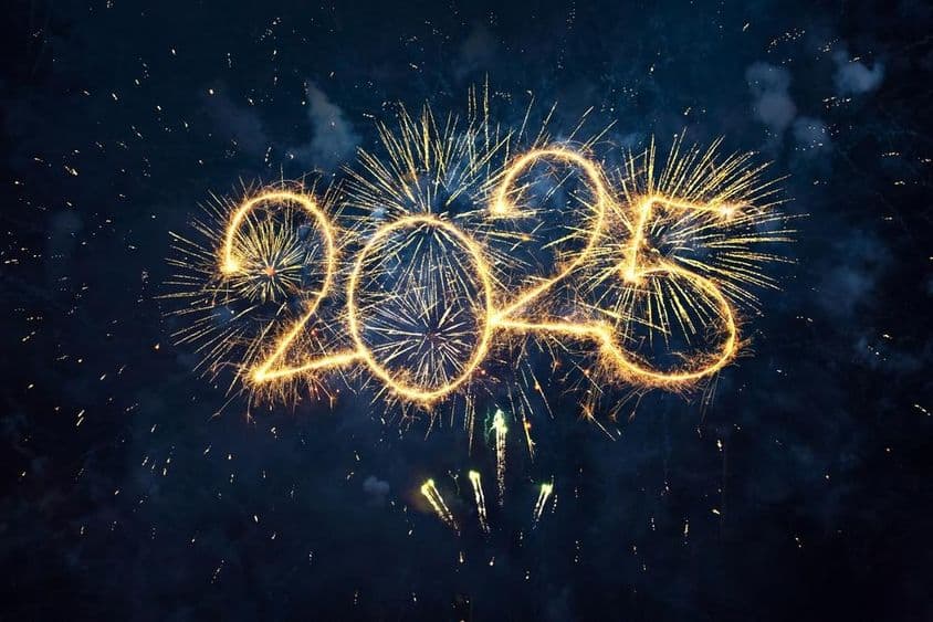 Feliz Año Nuevo 2025, fuegos artificiales dorados y números brillantes, 2025 contra un cielo azul nocturno.