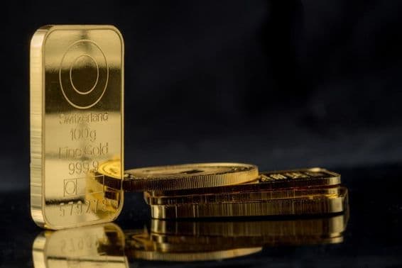 Barras de oro de varios pesos sobre un fondo espejo negro.