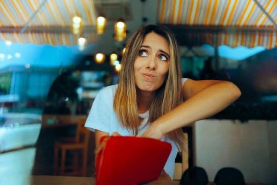 Mujer preocupada sin suficiente dinero debido a aumentos de precios.