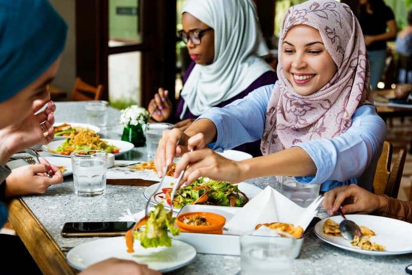 Mujeres musulmanas cenando con hijabs.