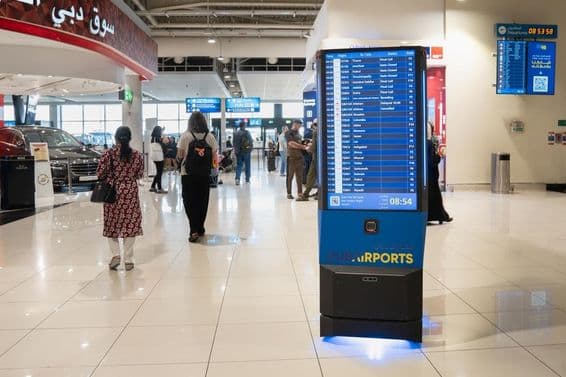 Interior del aeropuerto de Dubái con un panel de información.