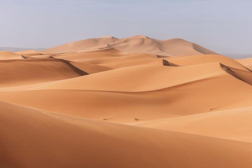 Dunas imponentes, atardecer dorado sobre un paisaje tranquilo y silencioso.