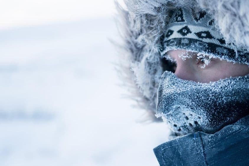 Un hombre con ropa de invierno y mascarilla, clima ártico frío
