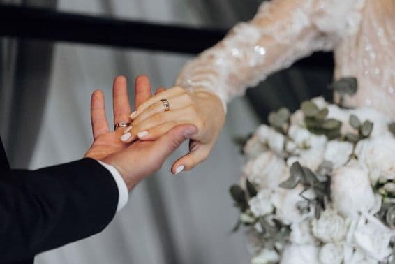 Novio y novia tomados de la mano, novia con vestido blanco.