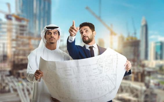 Arquitecto explicando el plan de construcción a constructores árabes