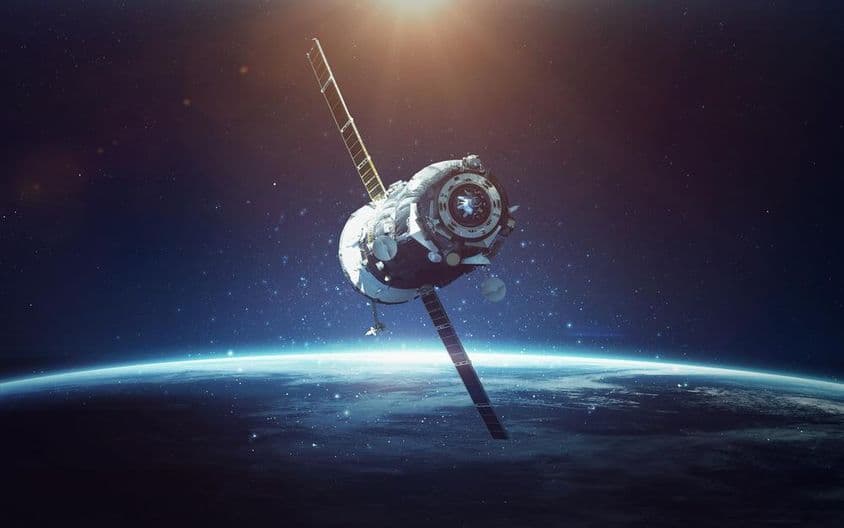 Satélite con planeta azul de fondo.