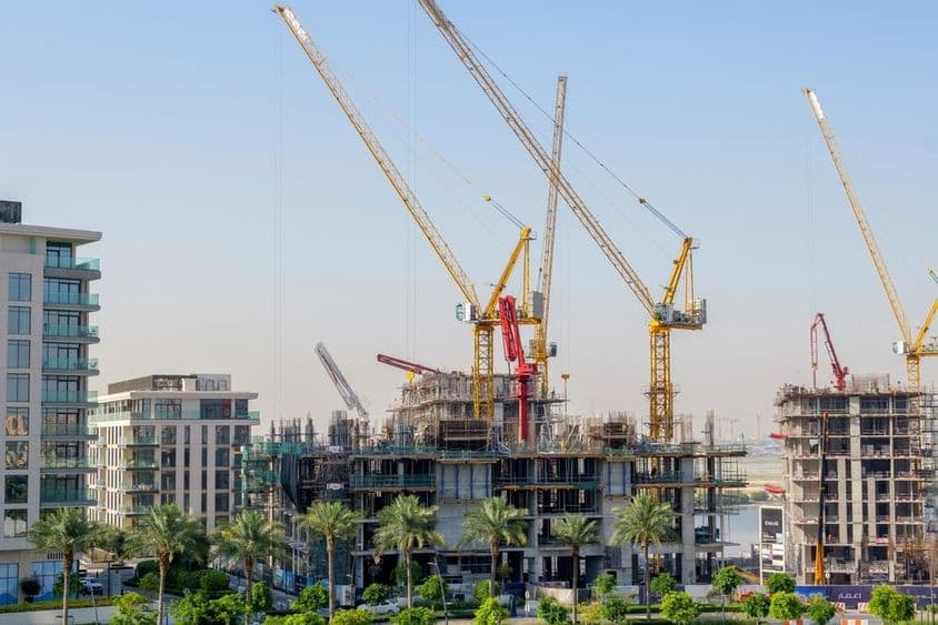 Edificios residenciales en construcción con grúas en el puerto de Dubai Creek.