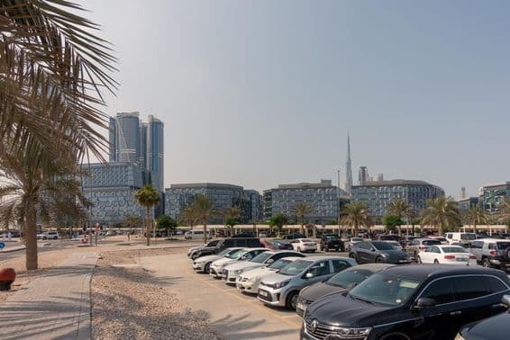 Zona de estacionamiento con vista a modernos edificios de oficinas en Dubái.