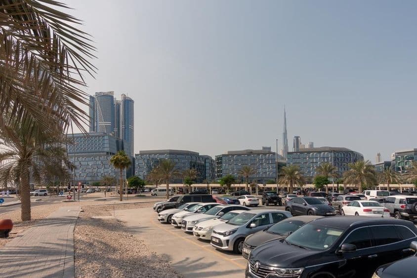 Zona de estacionamiento con vista a modernos edificios de oficinas en Dubái.
