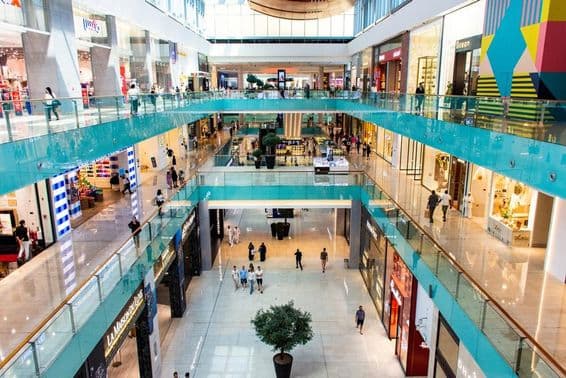 Turistas y visitantes caminando en una vista amplia del centro comercial Dubai Mall.