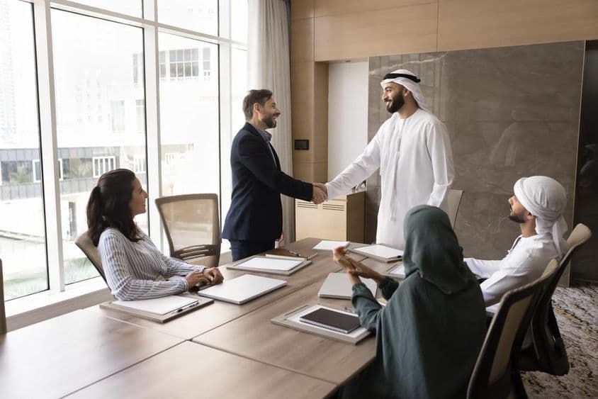 Empresarios árabes y europeos se dan la mano en una reunión de equipo, discusión corporativa.