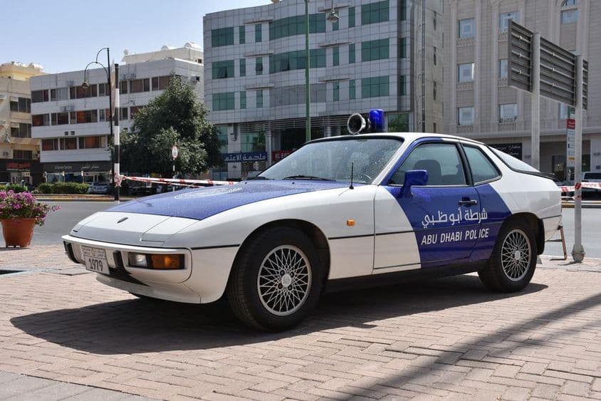 Exhibición de coche clásico de la policía de Abu Dhabi, patrulla azul y blanca.
