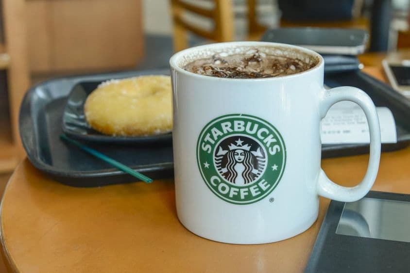 Cappuccino de cacao en una taza caliente y humeante en una cafetería Starbucks.
