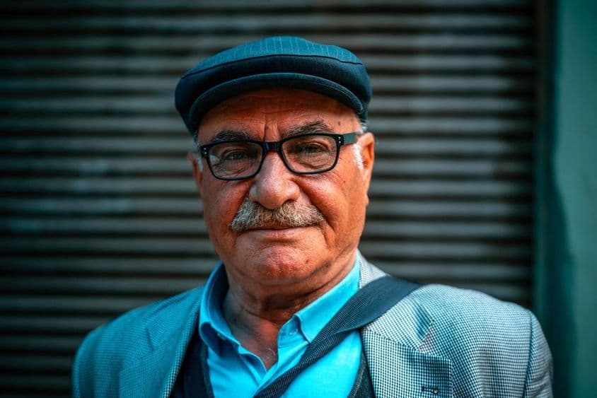 Hombre mayor con sombrero en la calle.