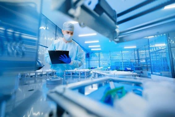 Trabajador farmacéutico operando una línea de producción en la industria farmacéutica.