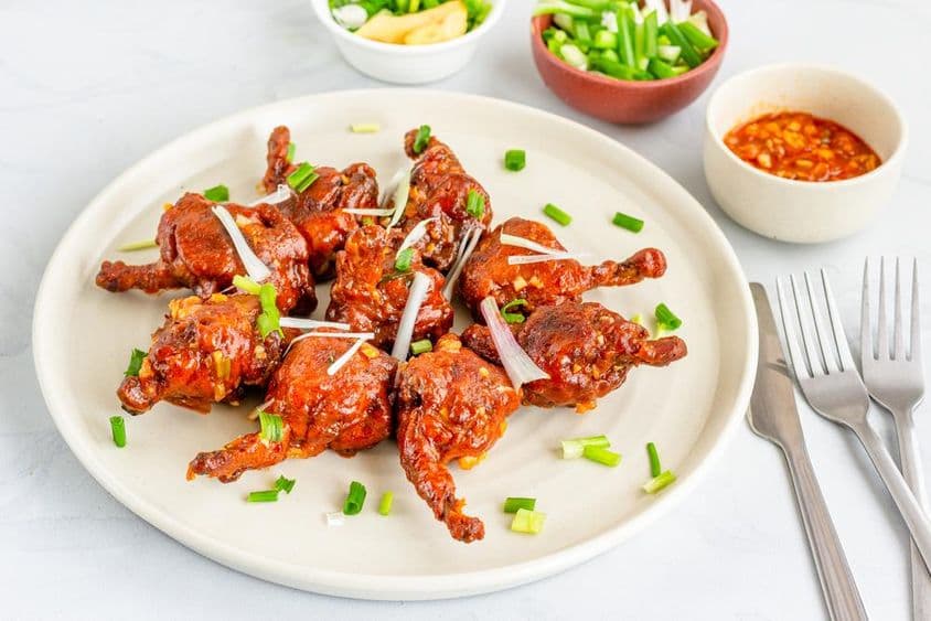 Chicken lollipop, un popular aperitivo de pollo adornado con chalotes.