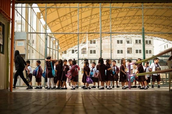 Niños caminando en un campus escolar.