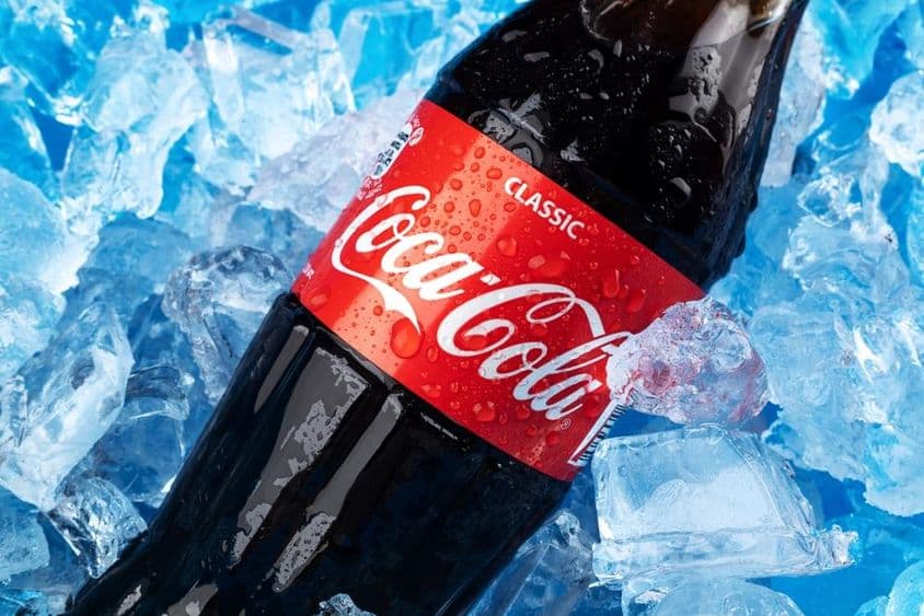 Una botella de Coca-Cola en hielo.