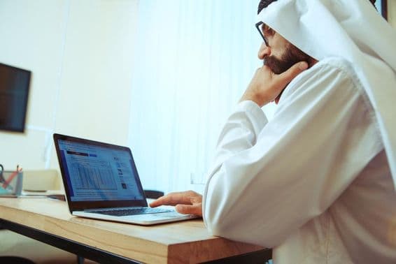 Empresario árabe trabajando en línea en una oficina cómoda.