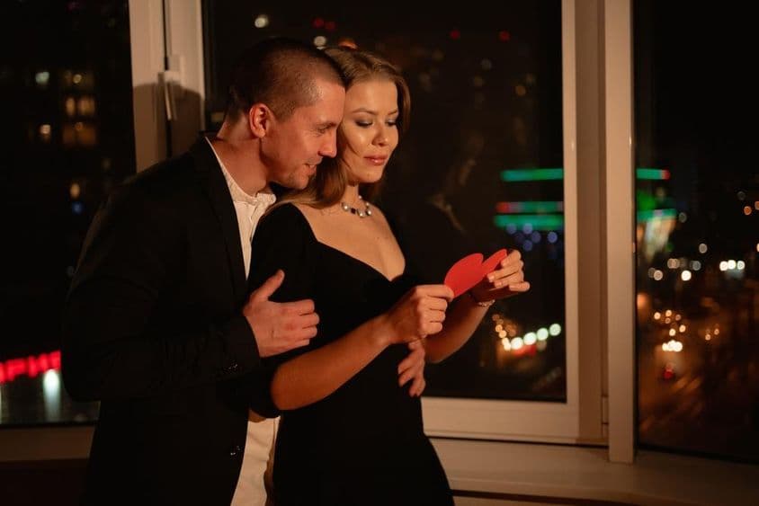 Pareja enamorada en una cita de San Valentín, junto a la ventana.