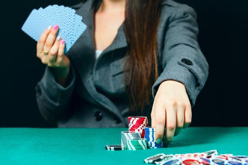 Blackjack en un casino, una mujer coloca una apuesta con fichas.
