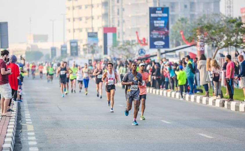 Corredores de maratón y ganadores durante un curso de medio maratón en la calle.