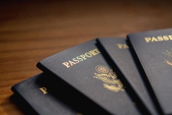 Pasaportes apilados sobre una mesa de madera.