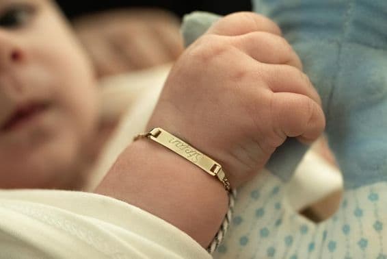 Un bebé con una pulsera de oro.