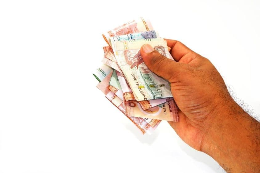 Billetes de dirham en la mano de un hombre.