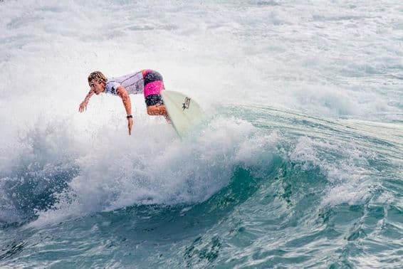 Joven practicando surf en una gran ola.