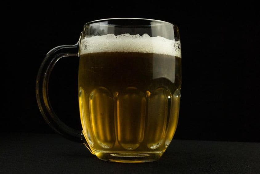Jarra de cerveza con una capa espumosa.
