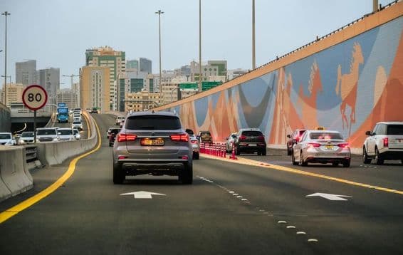 Tráfico de automóviles en una autopista con rascacielos de fondo en Dubái, Emiratos Árabes Unidos.
