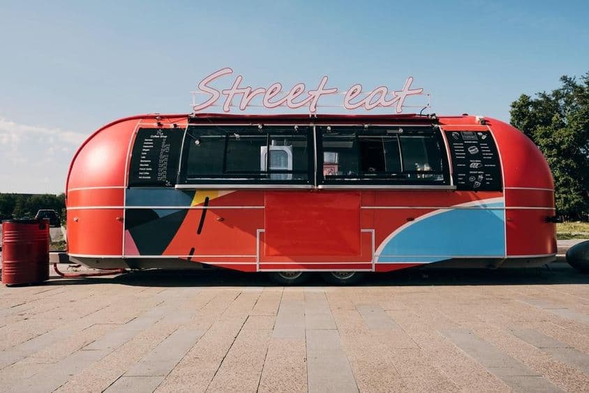 Camión de comida rojo, venta de comida rápida en medio de la calle o plaza.
