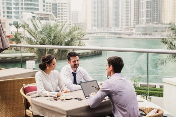 Reunión de negocios en un balcón moderno en Dubái Marina.