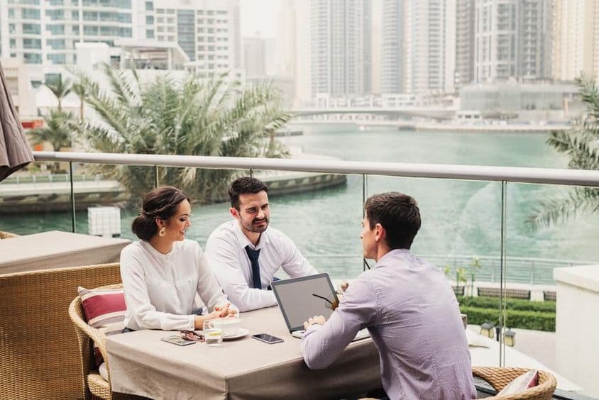 Reunión de negocios en un balcón moderno en Dubái Marina.