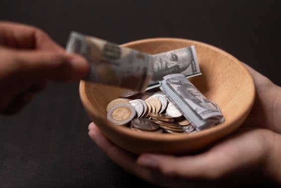 Donación siendo recolectada en un recipiente de madera.